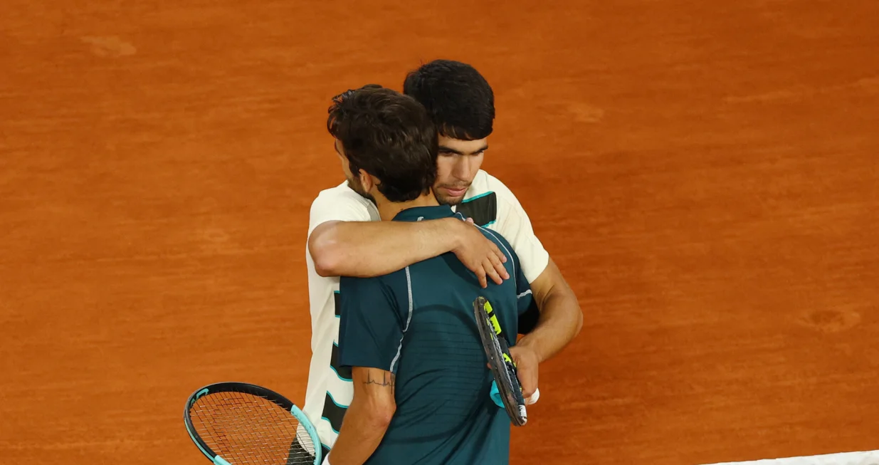 Tennis - French Open - Roland Garros, Paris, France - June 6, 2025 Italy's Lorenzo Musetti hugs Spain's Carlos Alcaraz as he walks off the court after retiring from the semi final match REUTERS/Lisi Niesner