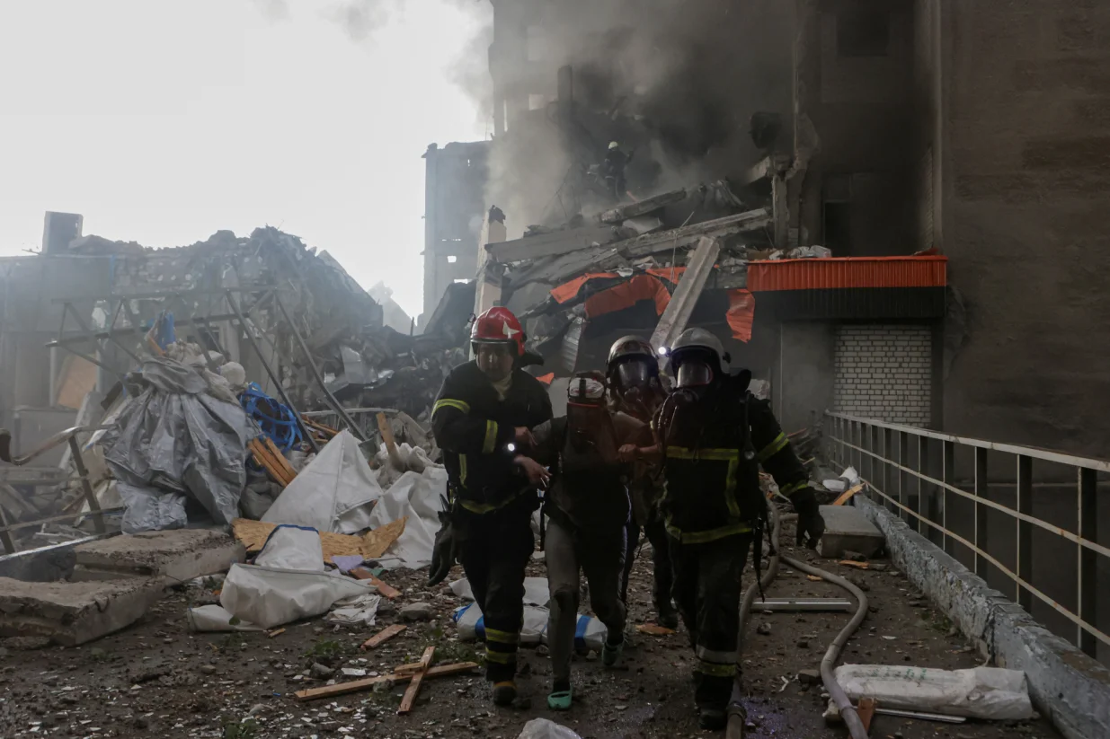 Rescuers assist an injured resident after she was released from debris of a building hit by a Russian drone strike, amid Russia's attack on Ukraine, in Kharkiv, Ukraine June 7, 2025. REUTERS/Sofiia Gatilova/Sofiia Gatilova