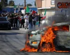Protesters stand near a car burning in flames following multiple detentions by Immigration and Customs Enforcement (ICE), in the Los Angeles County city of Paramount, California, U.S., June 7, 2025. REUTERS/Daniel Cole/Daniel Cole
