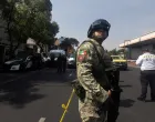FILE PHOTO: A member of the army stands guard, as police officers work at the scene, after two top members of Mexico City Mayor Clara Brugada's team were killed in what Mexican President Claudia Sheinbaum said was a direct attack, in Mexico City, Mexico, May 20, 2025. Picture partially taken through glass. REUTERS/Quetzalli Nicte-Ha/File Photo/Quetzalli Nicte-ha