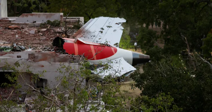 A tail of an Air India Boeing 787 Dreamliner plane that crashed is seen stuck on a building after the incident in Ahmedabad, India, June 12, 2025. REUTERS/Amit Dave/Amit Dave