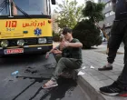An injured person sits on a roadside in the aftermath of Israeli strikes, in Tehran, Iran, June 13, 2025. Majid Asgaripour/WANA (West Asia News Agency) via REUTERS ATTENTION EDITORS - THIS PICTURE WAS PROVIDED BY A THIRD PARTY  TPX IMAGES OF THE DAY/Majid Asgaripour