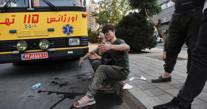 An injured person sits on a roadside in the aftermath of Israeli strikes, in Tehran, Iran, June 13, 2025. Majid Asgaripour/WANA (West Asia News Agency) via REUTERS ATTENTION EDITORS - THIS PICTURE WAS PROVIDED BY A THIRD PARTY  TPX IMAGES OF THE DAY/Majid Asgaripour