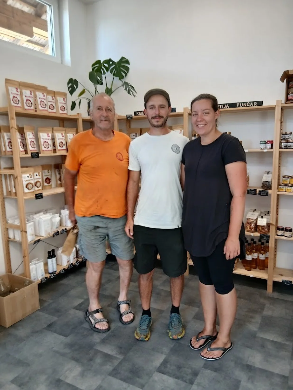 Otac, sin i snaha zadovoljno poziraju u vlastitoj trgovini/