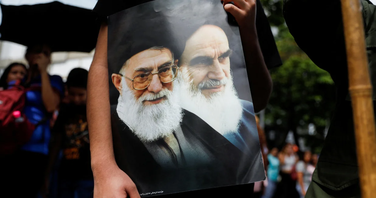 A Venezuelan government supporter holds a sign with an image of Iran's Supreme Leader Ayatollah Ali Khamenei and Iran's late leader Ayatollah Ruhollah Khomeini, while participating in a march in support of Iran amid the ongoing conflict between Israel and Iran, in Caracas, Venezuela June 19, 2025. REUTERS/Leonardo Fernandez Viloria/Leonardo Fernandez Viloria