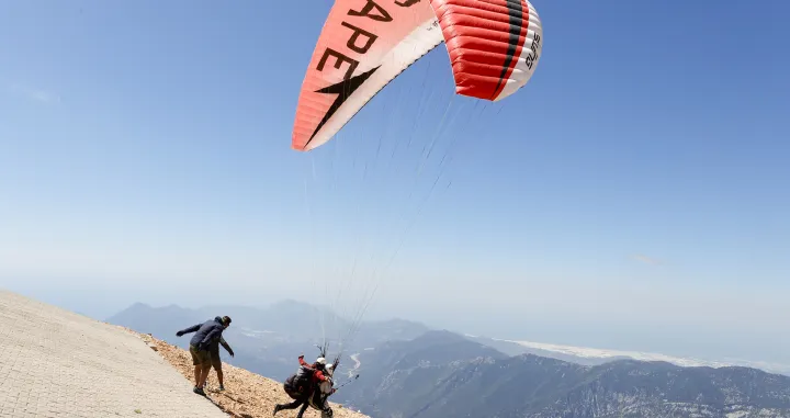 Ljubitelji paraglajdinga jedva su dočekali toplije vrijeme i priliku da se spuštaju sa planine Tahtali u Kemeru u Turskoj, javlja Anadolu Agency (AA)Planina Tahtali u Antaliji sa najvišim vrhom od 2.365 metara jedna je od najviših tačaka planinskog sistema Taurus, a sa nje se pruža pogled na mediteransku obalu. (Mustafa Çiftçi - Anadolu Agency)/Mustafa Çiftçi