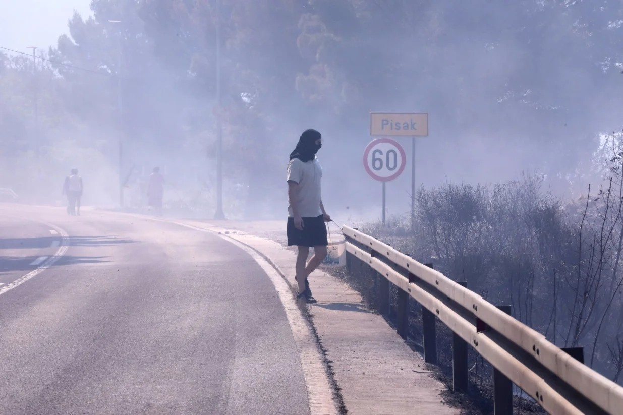 21.06.2025., Pisak - Rano jutros izbio je veliki pozar u sumi iznad magistrale. Bura otezava situaciju, a uz vatrogasce na terenu, u gasenju pozara sudjeluju i mjestani. Kako nesluzbeno doznaje Dalmacija Danas, u tijeku je evakuacija gradjana i turista. Photo: Ivo Cagalj/PIXSELL/Ivo Cagalj