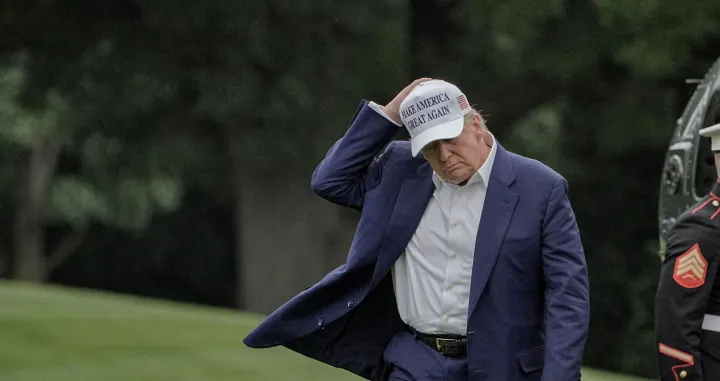 U.S. President Donald Trump holds his hat as he walks on the South Lawn of the White House in Washington, D.C., U.S., May 25, 2025. /Ken Cedeno/Ken Cedeno