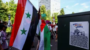 A demonstrator carries a Syrian flag used under Bashar al-Assad's rule, during a march against the upcoming NATO leaders' summit, at The Hague, Netherlands, June 22, 2025. REUTERS/Piroschka van de Wouw/Piroschka Van De Wouw