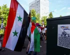 A demonstrator carries a Syrian flag used under Bashar al-Assad's rule, during a march against the upcoming NATO leaders' summit, at The Hague, Netherlands, June 22, 2025. REUTERS/Piroschka van de Wouw/Piroschka Van De Wouw