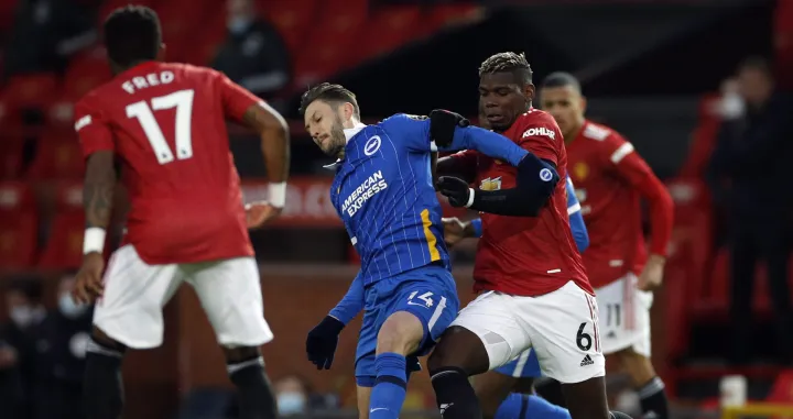 epa09115993 Paul Pogba (R) of Manchester United in action against Adam Lallana (C) of Brighton during the English Premier League soccer match between Manchester United and Brighton Hove Albion in Manchester, Britain, 04 April 2021. EPA/Phil Noble/POOL EDITORIAL USE ONLY. No use with unauthorized audio, video, data, fixture lists, club/league logos or 'live' services. Online in-match use limited to 120 images, no video emulation. No use in betting, games or single club/league/player publications.