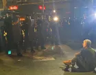 žena sjela pred kordon policije, vidovdan, protest beograd X/X