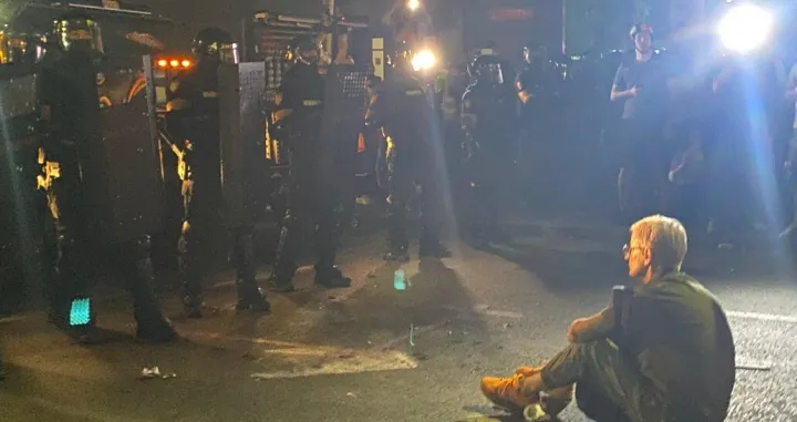 žena sjela pred kordon policije, vidovdan, protest beograd X/X