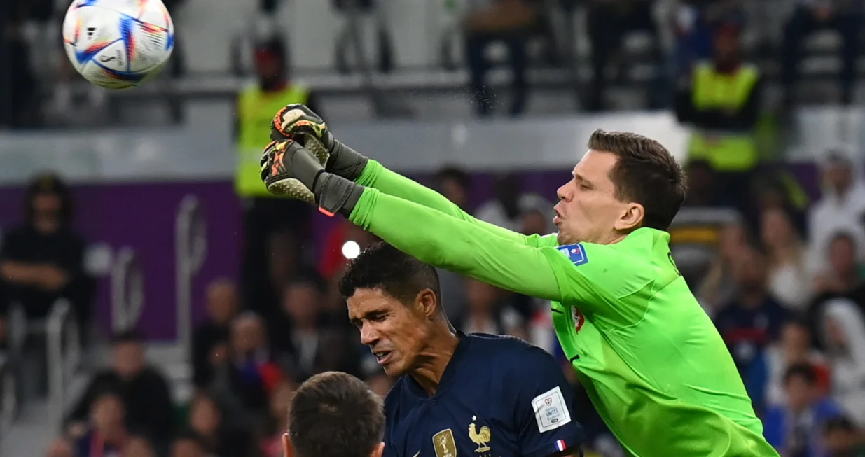 epa10348210 Goalkeeper Wojciech Szczesny (R) of Poland in action against Raphael Varane of France during the FIFA World Cup 2022 round of 16 soccer match between France and Poland at Al Thumama Stadium in Doha, Qatar, 04 December 2022. EPA/Georgi Licovski