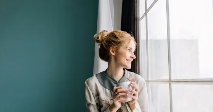 Djevojka pije čaj na prozoru//