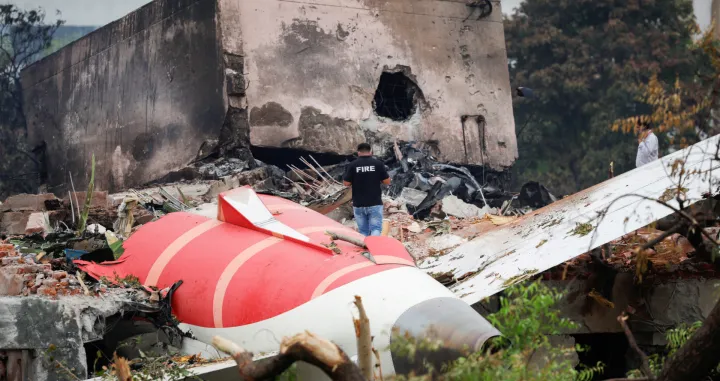 A fire officer stands next to the crashed Air India Boeing 787-8 Dreamliner aircraft, in Ahmedabad, India, June 13, 2025. REUTERS/Adnan Abidi  TPX IMAGES OF THE DAY/Adnan Abidi