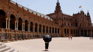 A woman uses an umbrella to protect herself from the sun during a heatwave in Seville, Spain, July 1, 2025. REUTERS/Marcelo del Pozo  TPX IMAGES OF THE DAY/Marcelo Del Pozo