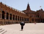 A woman uses an umbrella to protect herself from the sun during a heatwave in Seville, Spain, July 1, 2025. REUTERS/Marcelo del Pozo  TPX IMAGES OF THE DAY/Marcelo Del Pozo