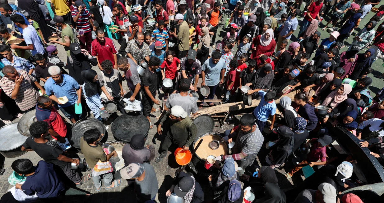 Palestinians gather to receive food from a charity kitchen, amid a hunger crisis, in Nuseirat, central Gaza Strip, July 20, 2025. REUTERS/Ramadan Abed/Ramadan Abed