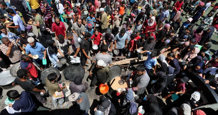 Palestinians gather to receive food from a charity kitchen, amid a hunger crisis, in Nuseirat, central Gaza Strip, July 20, 2025. REUTERS/Ramadan Abed/Ramadan Abed