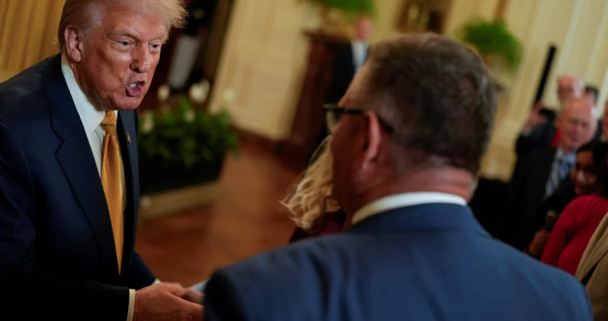 U.S. President Donald Trump speaks to an attendee as he hosts a dinner with Republican members of the U.S. Congress in the East Room of the White House in Washington, D.C., U.S., July 22, 2025. REUTERS/Kent Nishimura/Kent Nishimura