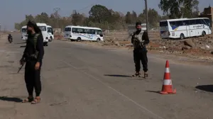 Internal Security Forces stand guard at a checkpoint as busses arrive for Syrian Arab Red Crescent's evacuation of civilians from Sweida, as part of an agreement between the Syrian government and Druze militants, in the Busra al-Harir area, Deraa Governorate, Syria July 23, 2025. REUTERS/Khalil Ashawi/Khalil Ashawi
