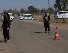 Internal Security Forces stand guard at a checkpoint as busses arrive for Syrian Arab Red Crescent's evacuation of civilians from Sweida, as part of an agreement between the Syrian government and Druze militants, in the Busra al-Harir area, Deraa Governorate, Syria July 23, 2025. REUTERS/Khalil Ashawi/Khalil Ashawi