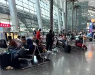 FILE PHOTO: People sit at Hamad International Airport after Qatar reopened its airspace following a brief closure in the wake of Iran's missile attack on Al Udeid Air Base on Monday, in Doha, Qatar, June 24, 2025. REUTERS/Stringer/File Photo/Stringer