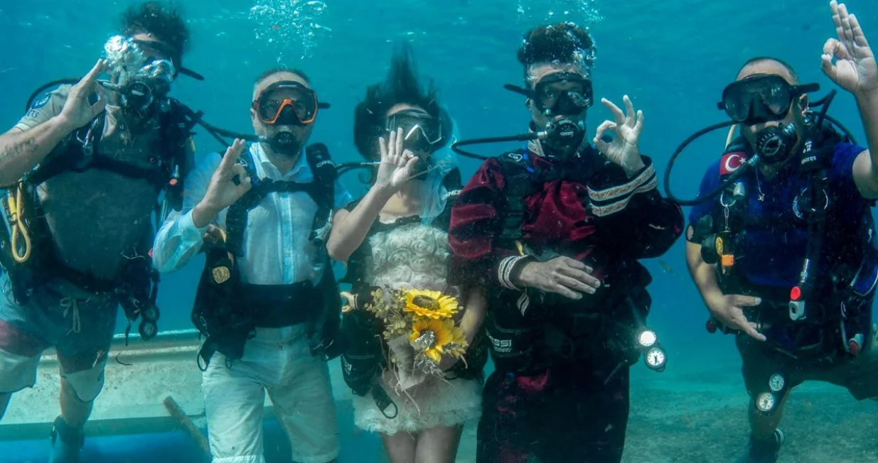 CANAKKALE, TURSKA - 27. JULI 2025.Amaterski ronilac Ilhami Bilecen i medicinska tehničarka Ozlem Sayin odlučili su da se vjenčaju pod vodom u zaljevu gdje su se i upoznali.Par, zaljubljen u more, sklopio je brak pod vodom u okrugu Gelibolu, u zapadnoj turskoj provinciji Canakkale.Nakon priprema, mladoženja i mlada, zajedno s gradonačelnikom Gelibolua Alijem Kamilom Soyuakom i svjedocima, zaronili su s opremom.Pod vodom su razvili transparent s natpisom "Da", nakon čega su se vratili na obalu i zvanično potpisali matičnu knjigu vjenčanih pred gostima. (Gelibolu Belediyesi - Anadolu Agency)/Anadolija