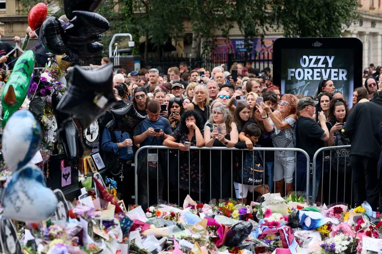 People gather near tributes placed at the Black Sabbath Bridge, named in honour of the heavy metal band, on the day of the funeral cortege of Ozzy Osbourne, its former frontman, in Birmingham, Britain, July 30, 2025. REUTERS/Jack Taylor/Jack Taylor