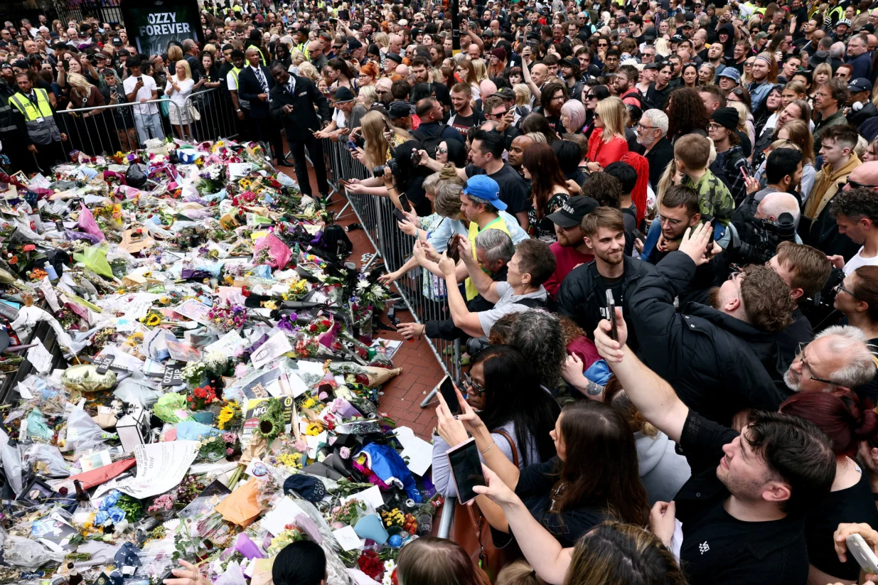 People gather around tributes placed at the Black Sabbath Bridge, named in honour of the heavy metal band, on the day of the funeral cortege of Ozzy Osbourne, its former frontman, in Birmingham, Britain, July 30, 2025. REUTERS/Jack Taylor  TPX IMAGES OF THE DAY/Jack Taylor