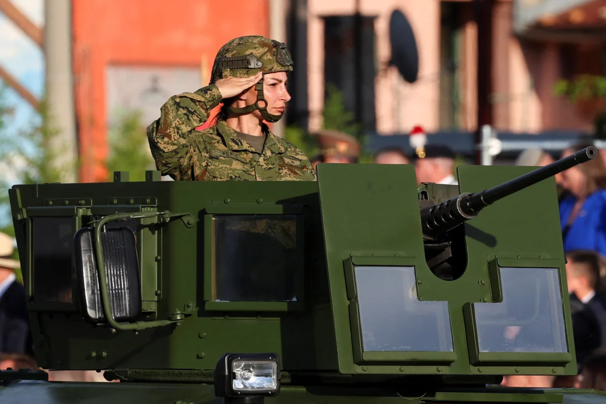 A member of Croatia's military salutes from an armored vehicle at a military parade for the 30th anniversary of Operation Storm alongside Victory Day, Homeland Thanksgiving Day, and Croatian Veterans Day, in downtown Zagreb, Croatia, July 31, 2025. REUTERS/Antonio Bronic/Antonio Bronic