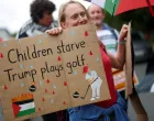 A woman holds a placard as demonstrators protest the visit of U.S. President Donald Trump, in Balmedie, near Aberdeen, Scotland, Britain, July 28, 2025. REUTERS/Hannah McKay/Hannah Mckay