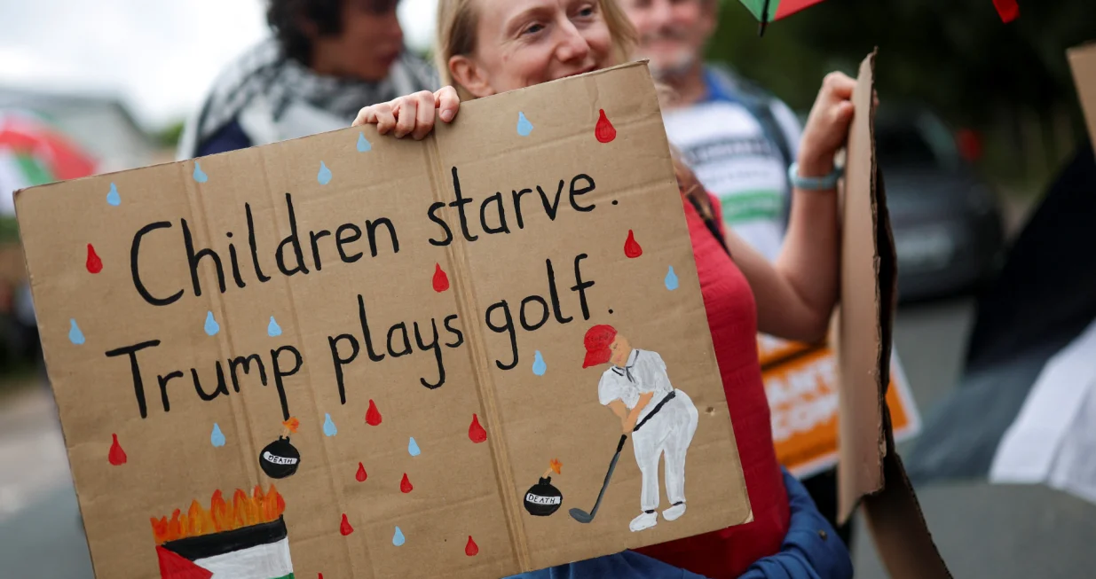 A woman holds a placard as demonstrators protest the visit of U.S. President Donald Trump, in Balmedie, near Aberdeen, Scotland, Britain, July 28, 2025. REUTERS/Hannah McKay/Hannah Mckay