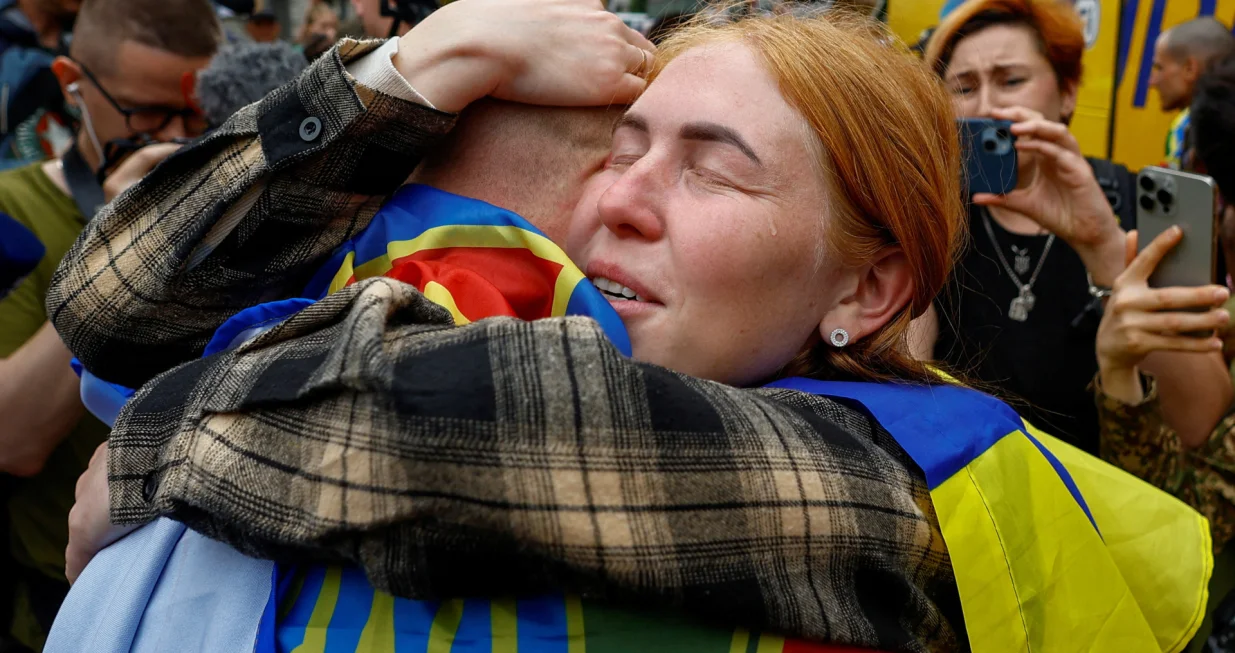 A woman reacts as she embraces her husband, a Ukrainian prisoner of war (POW) who returns after a swap, amid Russia's attack on Ukraine, in an undisclosed location in Ukraine, May 25, 2025. REUTERS/Valentyn Ogirenko  TPX IMAGES OF THE DAY/Valentyn Ogirenko