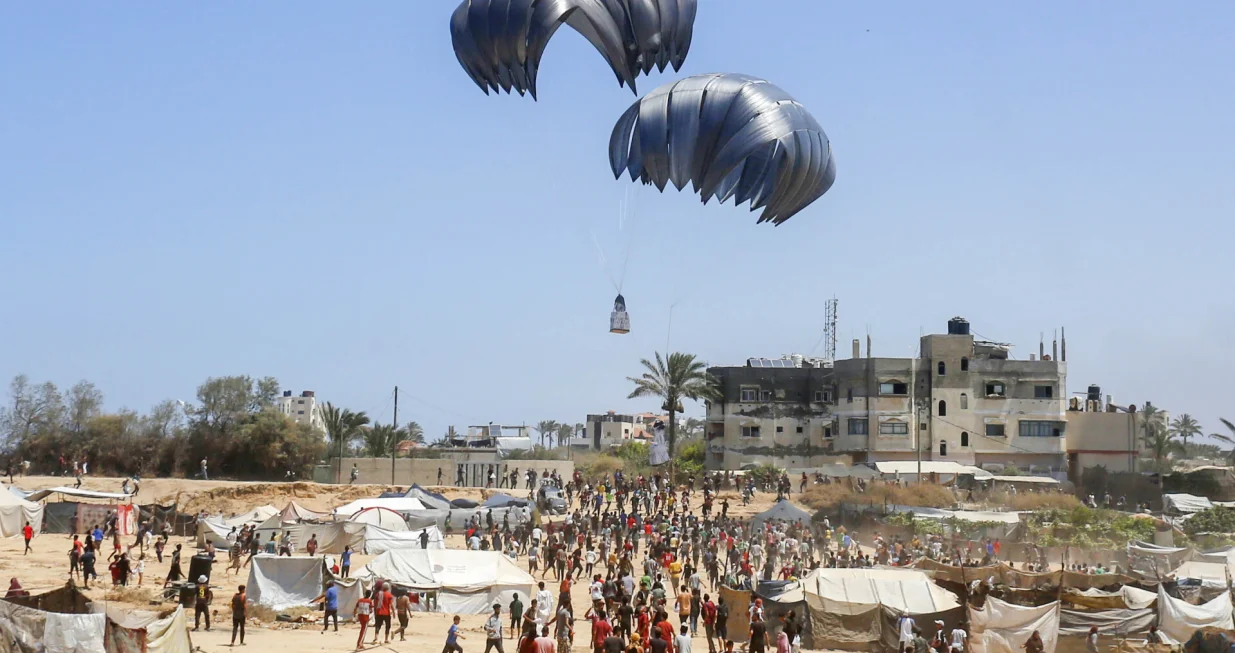 DEIR AL BALAH, GAZA - 4. AUGUST:Avion iz zraka ispušta humanitarnu pomoć padobranom iznad područja Al-Zawaida u Deir al-Balahu, Gaza, 4. augusta 2025. Palestinci se bore da prime pomoć koju ispuštaju vojni teretni avioni. Pokušaji spuštanja humanitarne pomoći padobranom u Pojas Gaze, koji je pod izraelskim napadom i embargom, se nastavljaju. (Mohammed Nassar - Anadolu Agency)/