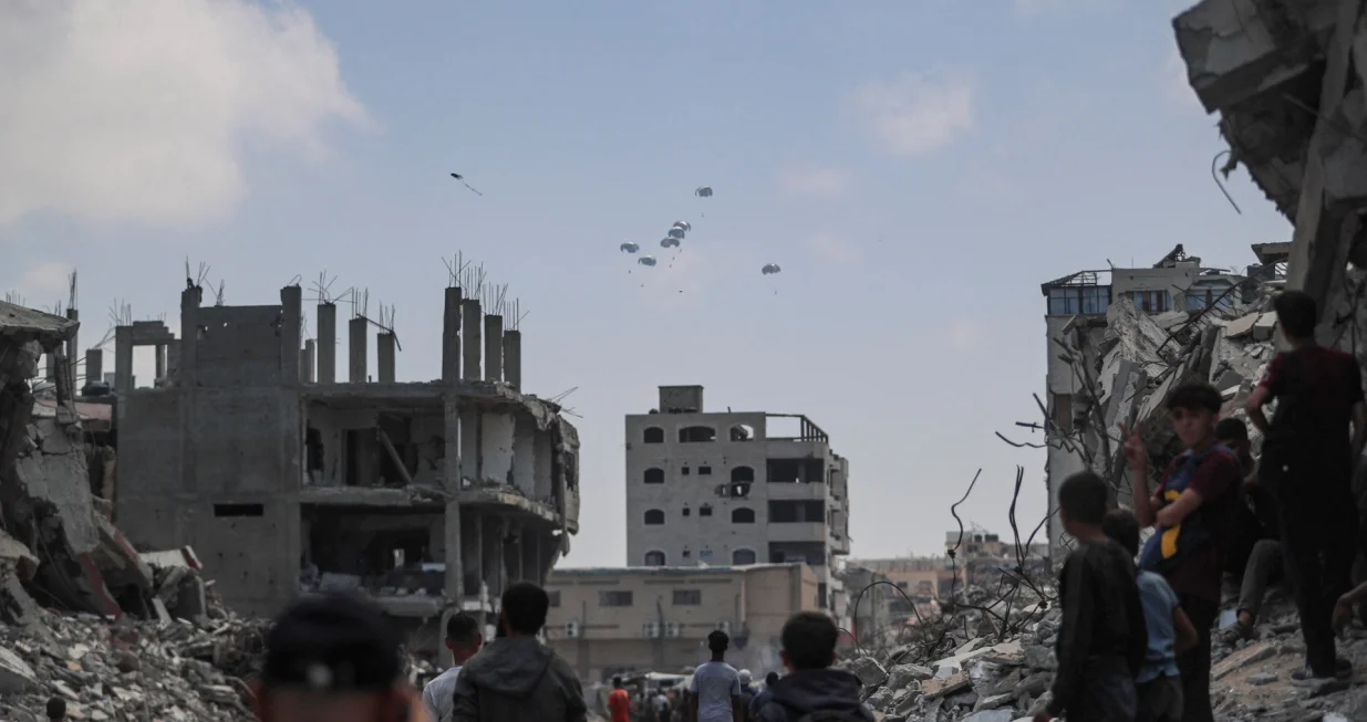 Palestinians look at aid packages that are airdropped over Gaza, in Gaza City, August 8, 2025. REUTERS/Mahmoud Issa/Mahmoud Issa