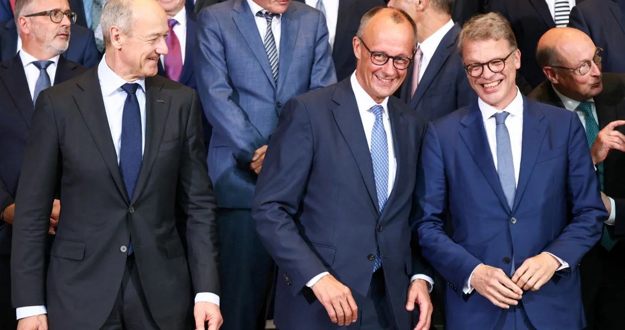 German Chancellor Friedrich Merz, Siemens AG CEO Roland Busch and Deutsche Bank CEO Christian Sewing react as they pose for a group photo with members of the "Made for Germany" initiative at the Chancellery in Berlin, Germany, July 21, 2025. REUTERS/Liesa Johannssen/Liesa Johannssen