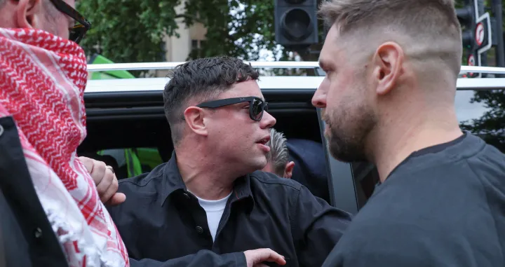 Member of Kneecap Naoise O Caireallain, who performs under the name of Moglai Bap arrives at the Westminster Magistrates' Court, on the day Kneecap member Liam O'Hanna, also known as Liam Og O hAnnaidh and performing under the name of Mo Chara, who has been charged with a terrorism offence in relation to the alleged display of a Hezbollah flag onstage in 2024, appears in court, in London, Britain, August 20, 2025. REUTERS/Hannah McKay/Hannah Mckay