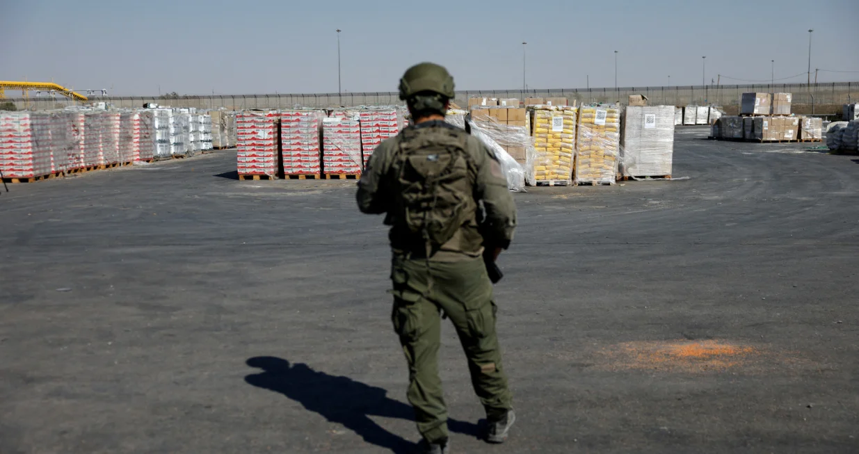 An Israeli soldier stands next to the parcels of humanitarian aid awaiting to be transferred into Gaza from Israel, at the Gaza part of the Kerem Shalom crossing in the Gaza Strip, July 24, 2025. REUTERS/Amir Cohen EDITOR'S NOTE: REUTERS PHOTOGRAPHS WERE REVIEWED BY THE IDF AS PART OF THE CONDITIONS OF THE EMBED. NO PHOTOS WERE REMOVED./Amir Cohen