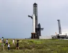 FILE PHOTO: Rocket fans walk in the sand dunes as they look over the SpaceX Starship spacecraft before it?s connected to a heavy booster at the launch pad at the company's complex in Starbase, Texas, U.S., August 23, 2025. REUTERS/Steve Nesius/File Photo/Steve Nesius
