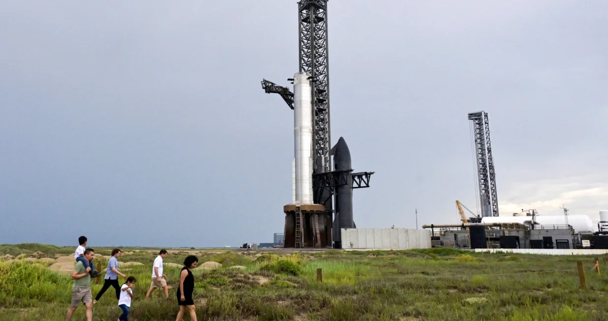FILE PHOTO: Rocket fans walk in the sand dunes as they look over the SpaceX Starship spacecraft before it?s connected to a heavy booster at the launch pad at the company's complex in Starbase, Texas, U.S., August 23, 2025. REUTERS/Steve Nesius/File Photo/Steve Nesius