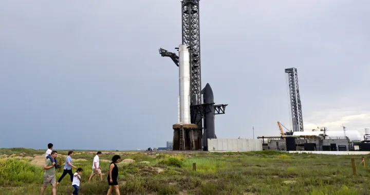 FILE PHOTO: Rocket fans walk in the sand dunes as they look over the SpaceX Starship spacecraft before it?s connected to a heavy booster at the launch pad at the company's complex in Starbase, Texas, U.S., August 23, 2025. REUTERS/Steve Nesius/File Photo/Steve Nesius