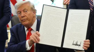 U.S. President Donald Trump holds up an executive order after signing it in the Oval Office at the White House in Washington, D.C., U.S., August 25, 2025. REUTERS/Jonathan Ernst  TPX IMAGES OF THE DAY/Jonathan Ernst