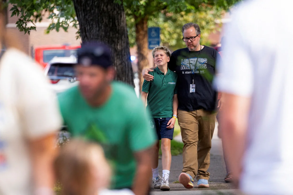 Families and loved ones walk outside the police barricades after a shooting at Annunciation Church, which is also home to an elementary school, in Minneapolis, Minnesota, U.S. August 27, 2025. REUTERS/Ben Brewer/Ben Brewer