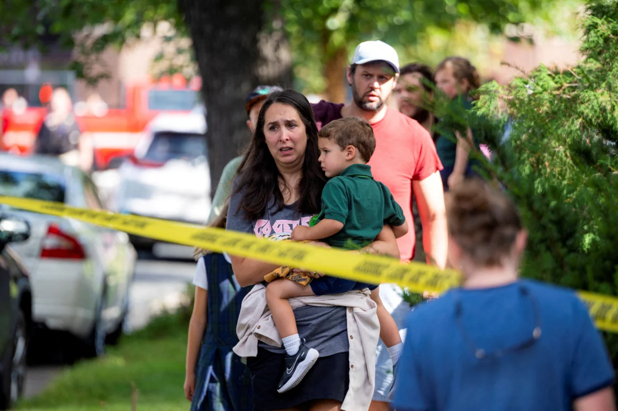 Families reunite outside the police barricades after a shooting at Annunciation Church, which is also home to an elementary school, in Minneapolis, Minnesota, U.S. August 27, 2025. REUTERS/Ben Brewer/Ben Brewer