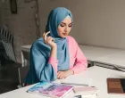 young pretty modern muslim woman in hijab working on laptop in office room, education online, remote work freelancer, making notes thinking, hidžab, posao, žena/Freepik
