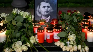 Roses and candles are placed next to a picture of Charlie Kirk during a vigil under the line "In Memory of Charlie Kirk, for freedom, patriotism and justice" in front of the Embassy of the United States after U.S. right-wing activist, commentator, Charlie Kirk, an ally of U.S. President Donald Trump, was shot dead during an event at Utah Valley University, Orem, U.S., in Berlin, Germany September 11, 2025. REUTERS/Annegret Hilse/Annegret Hilse