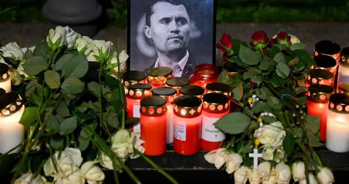 Roses and candles are placed next to a picture of Charlie Kirk during a vigil under the line "In Memory of Charlie Kirk, for freedom, patriotism and justice" in front of the Embassy of the United States after U.S. right-wing activist, commentator, Charlie Kirk, an ally of U.S. President Donald Trump, was shot dead during an event at Utah Valley University, Orem, U.S., in Berlin, Germany September 11, 2025. REUTERS/Annegret Hilse/Annegret Hilse
