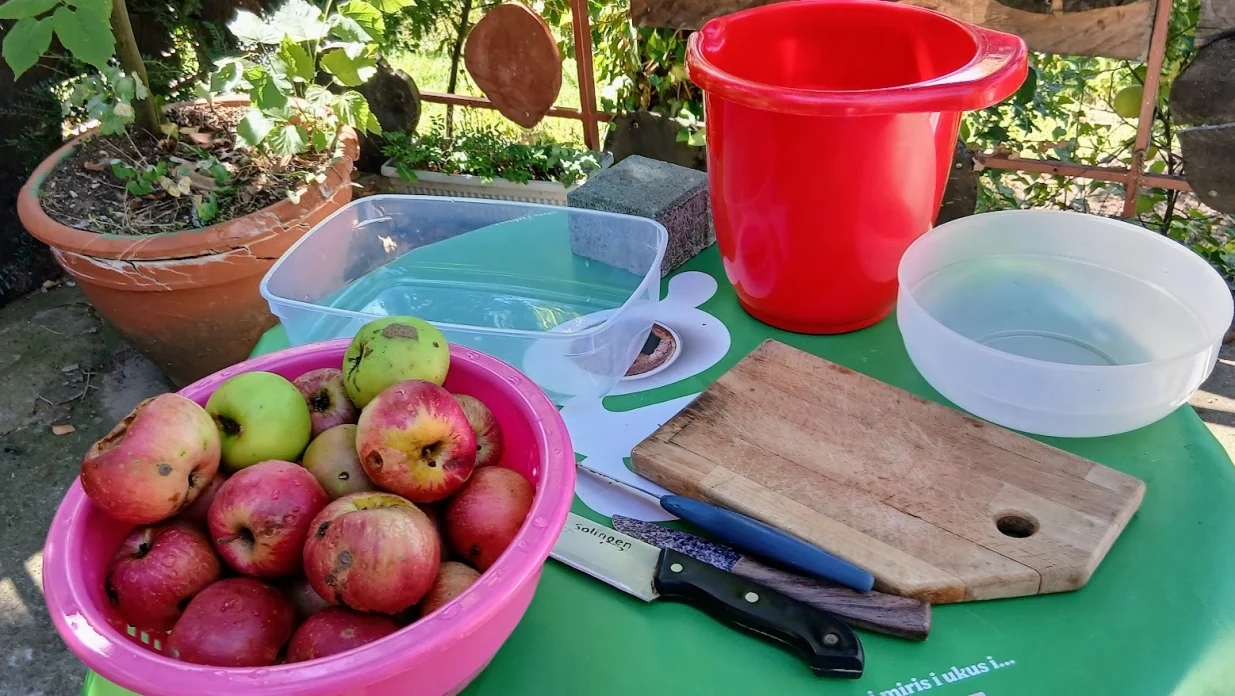 Jabuke, daska, nož, posude za otpad i za ploške/
